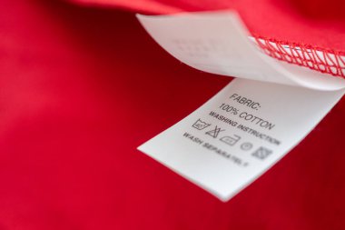 Beyaz çamaşır yıkama talimatları kırmızı pamuklu gömlekte etiket