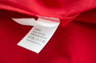 Beyaz çamaşır yıkama talimatları kırmızı pamuklu gömlekte etiket