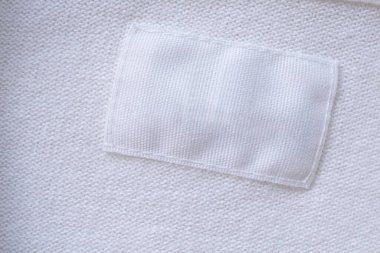 Yeni gömlek arka planında boş beyaz giysi etiketi