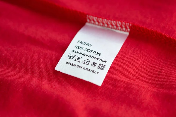 Beyaz çamaşır yıkama talimatları kırmızı pamuklu gömlekte etiket