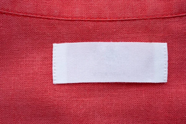 Etiqueta Blanca Etiqueta Ropa Blanco Sobre Tela Camisa Lino Rojo — Foto de Stock