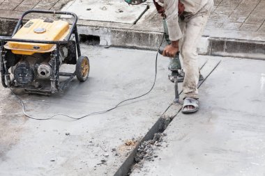 İnşaat işçisi beton sondaj yüzeyi kullanıyor.