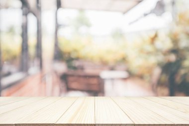 Boş ahşap masa üstü, kafeterya kahvesi, iç mekan, soyut bulanıklık, montaj ürünü gösterimi için bokeh ışığı arkaplanı.