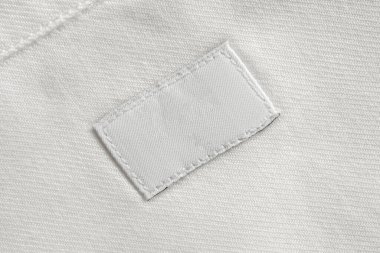 Pamuk gömlek arka planında beyaz kuru temizleme giysileri etiketi