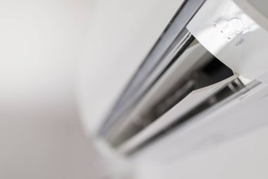 Beyaz duvar odasının arka planında klima var.