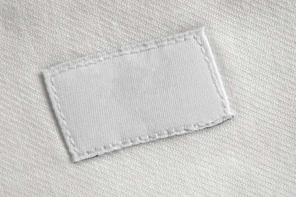 Cucian Putih Kosong Label Pakaian Pada Latar Belakang Kemeja Katun — Stok Foto