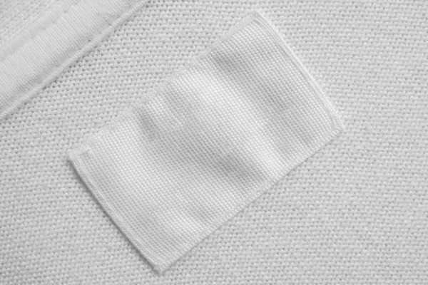 Cucian Putih Kosong Label Pakaian Pada Latar Belakang Kemeja Katun — Stok Foto