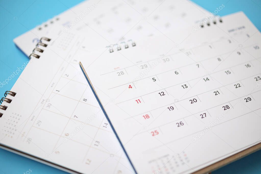 calendar page close up on blue background business planning appointment meeting concept