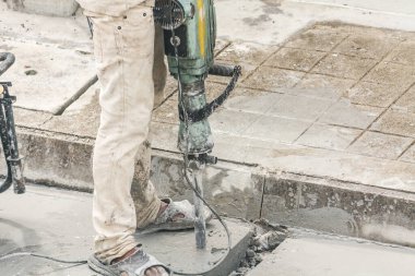 İnşaat işçisi beton sondaj yüzeyi kullanıyor.