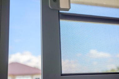 Ev penceresinin böceklere karşı korunması için sivrisinek ağı ekranını aç