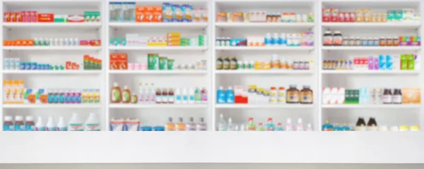 Empty wood counter top with pharmacy drugstore shelves blur pharmaceutical medicine product background