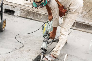 İnşaat işçisi beton sondaj yüzeyi kullanıyor.