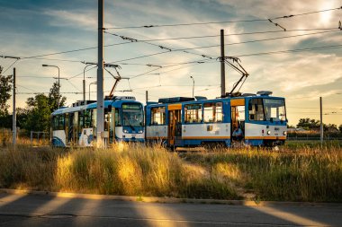 Tramvaylarda mola veren tramvay şoförleri sarı bir günbatımının önünde