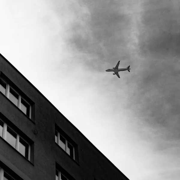 Увеличенная Фотография Самолета Пролетающего Над Старым Социалистическим Зданием — стоковое фото