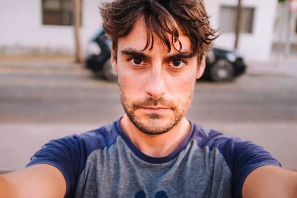 Tişörtlü ciddi genç adamın selfie 'si.
