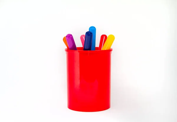 Beyaz arka planda izole edilmiş camdaki renkli kalemler.