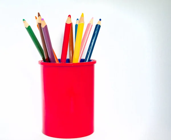 Beyaz arka planda izole edilmiş camdaki renkli kalemler.