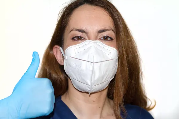 Beyaz arka planda yüz maskesi olan kadın portresi. Kapat.