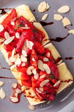 Mevsim yaz tost brie veya camembert peyniri ve çilek ile gri plaka üzerinde badem pul süslenmiş. Lezzetli yaz kahvaltı ve öğle yemeği