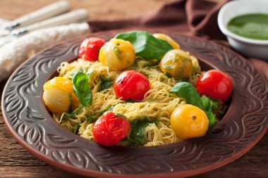 Spagetti ile renkli demlenmiş kiraz domates, fesleğen ve pesto sos seramik plaka