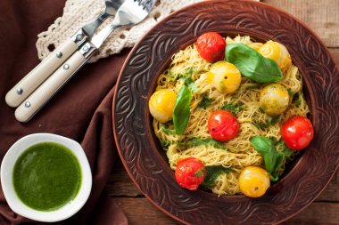 Spagetti ile renkli demlenmiş kiraz domates, fesleğen ve pesto sos seramik plaka