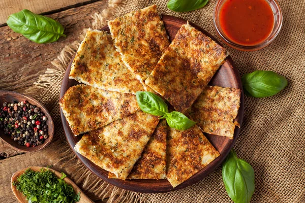 Karnabahar, peynir ve otlar, yapılmış Breadsticks taze fesleğen yaprakları ve kırmızı sos ile servis edilir