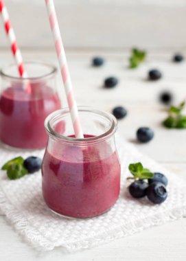 Blueberry smoothie beyaz tahta masada iki kavanoz