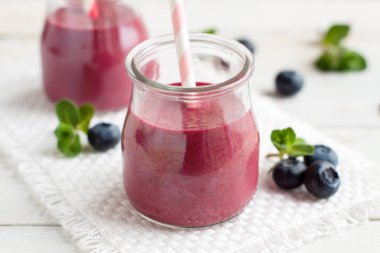 Blueberry smoothie beyaz tahta masada iki kavanoz