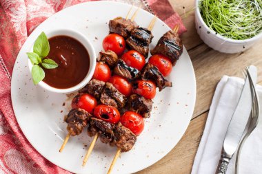 Balsamik biftek şişleri kiraz domates ve beyaz tabakta ketçap sos ile