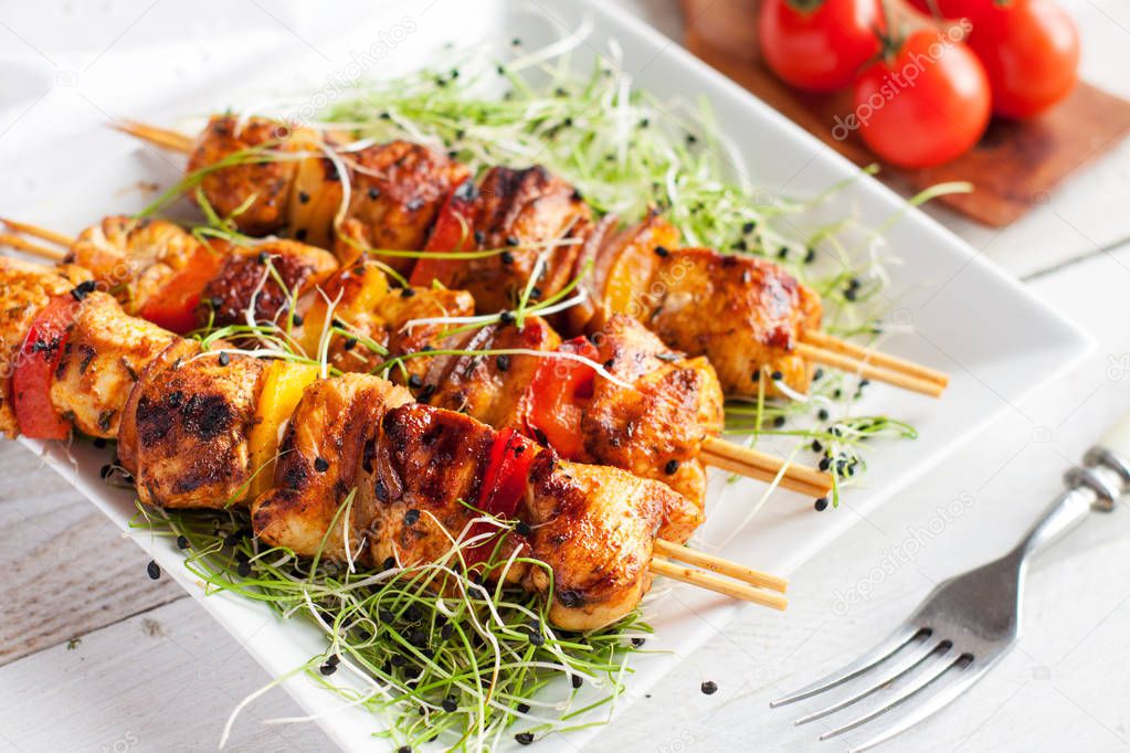 Mediterranean grilled chicken skewers served with microgreen and cherry tomatoes