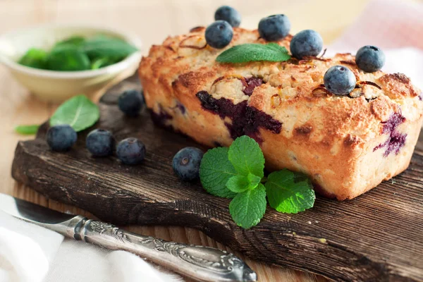 Healthy vegan sweet lemon bread with blueberries on rustic cutting board