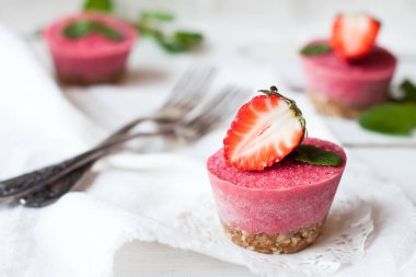 Vegan tatlı - çilek cheesecakes nane ile dekore edilmiş ve tablo üzerinde taze çilek beyaz çiğ