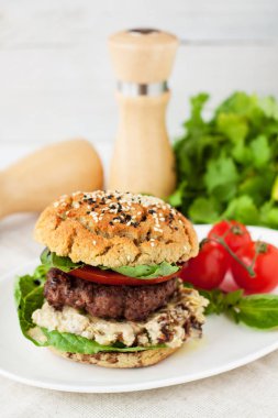 Ev yapımı Hamburger gluten ücretsiz topuz, Dana pirzola, domates, kıvırcık salata, pesto sos ile
