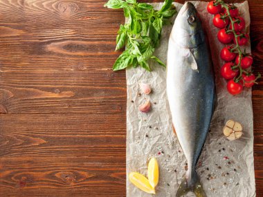 Bütün taze ton balığı domates, sarımsak ve baharat ile üstten görünüm ahşap arka plan üzerinde