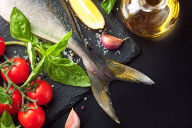 Limon, fesleğen, sarımsak ve baharat koyu arka plan üzerinde taze ton balığı