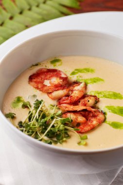 Izgara karides ve taze yeşillik, ahşap masa üzerinde beyaz kase hizmet lezzetli krem peynir çorbası