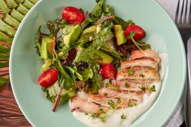 Sağlıklı sebze salatası ve ahşap masa üzerinde krema sos ile kase tavada kızartılmış kalamar halkaları