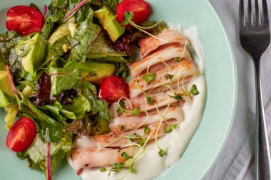 Sağlıklı sebze salatası ve ahşap masa üzerinde krema sos ile kase tavada kızartılmış kalamar halkaları