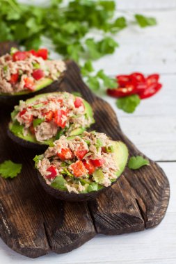 Konserve ton balığı, dolmalık biber, ahşap kesme tahtası üzerinde otlar ile doldurulmuş avokado meze