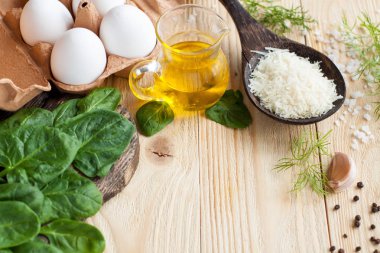Sağlıklı kahvaltı - yumurta, ıspanak, zeytin yağı, parmesan peyniri, sarmısak, tuz ve biber için malzemeler