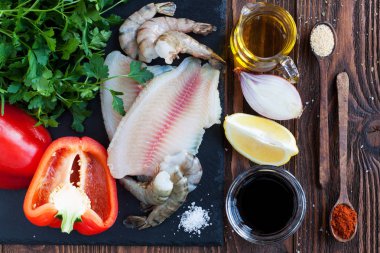 Deniz ürünleri yemek - tilapia fileto, karides, kırmızı dolmalık biber, soğan, limon, baharatlar, zeytinyağı ve soya sosu için ham maddeler