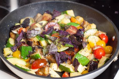 Doğranmış kabak, patlıcan, domates ile baharat ve tavada fesleğen salata soslarında