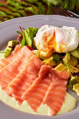 Haşlanmış yumurta, füme somon, sebze ve yeşillik salatası ahşap masa, sağlıklı kahvaltı kavramı üzerinde