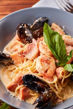 Deniz ürünleri makarna midye, mürekkep balığı, somon fileto ve kaplan ile sarımsak krem sos ve parmesan peyniri ile karides