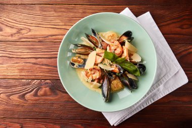 Çeşitli deniz ürünleri, midye, mürekkep balığı, tarak, somon fileto ve kaplan karides fesleğen sarımsak kremalı sos, parmesan peyniri ile