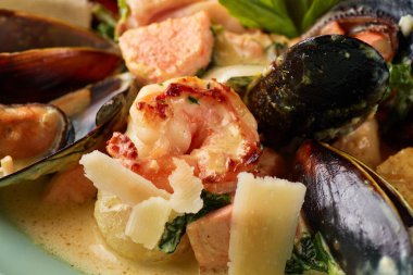 Çeşitli deniz ürünleri, midye, mürekkep balığı, tarak, somon fileto ve kaplan karides fesleğen sarımsak kremalı sos, parmesan peyniri ile