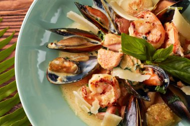 Çeşitli deniz ürünleri, midye, mürekkep balığı, tarak, somon fileto ve kaplan karides fesleğen sarımsak kremalı sos, parmesan peyniri ile