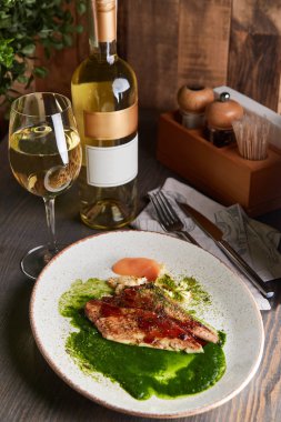 Izgara beyaz balık fileto kavrulmuş karnabahar, yeşil baharatlı tereyağı ve şarap ile hizmet elma sosu ile