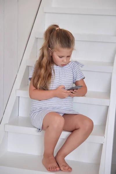 Retrato Niña Rubia Absorbedly Mirando Teléfono Mientras Está Sentado Escalera — Foto de Stock