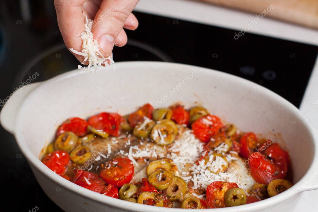 Añadir queso parmesano rallado a la cazuela con filetes de tilapia